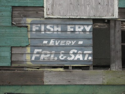 New Orleans: Weathered old sign on side of building Uptown, advertising " Fish Fry" held every Friday and Saturday